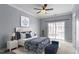 Bright bedroom with a ceiling fan, light blue walls, and a bed with blue and white accents at 10321 Sablewood Dr # 108, Raleigh, NC 27617