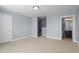 A spacious carpeted room features neutral walls and connects to an adjacent bathroom and stairway at 10321 Sablewood Dr # 108, Raleigh, NC 27617