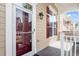 Charming front door with glass and a porch with white railing and visible window with red shutters at 10321 Sablewood Dr # 108, Raleigh, NC 27617