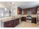 Spacious kitchen with granite countertops, stainless steel appliances, and dark wood cabinets at 10321 Sablewood Dr # 108, Raleigh, NC 27617