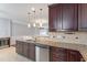 Gourmet kitchen featuring granite countertops, stainless steel dishwasher, and dark wood cabinets at 10321 Sablewood Dr # 108, Raleigh, NC 27617