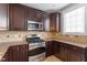 Modern kitchen with granite countertops, stainless steel oven, and dark wood cabinets at 10321 Sablewood Dr # 108, Raleigh, NC 27617