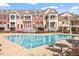 An inviting outdoor pool with lounge chairs, tables, and upscale homes in the background at 10321 Sablewood Dr # 108, Raleigh, NC 27617