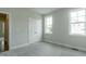 Large windows allow natural light into this bedroom with neutral walls and carpet, and dual closets at 104 Bearwallow Forest Way, Wendell, NC 27591