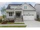Charming craftsman home featuring stone accents, a two-car garage, and a welcoming covered front porch at 104 Bearwallow Forest Way, Wendell, NC 27591