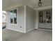 Spacious covered porch featuring a stylish front door and a view of the home's light-colored siding at 104 Bearwallow Forest Way, Wendell, NC 27591