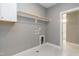 Neutral laundry room with white cabinets, open shelf, and washer-dryer hookups at 104 Bearwallow Forest Way, Wendell, NC 27591