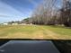 View from patio of home's backyard, featuring a mix of green and dormant grass and woods in the distance at 107 Faucette Dr, Selma, NC 27576