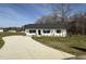 Charming single-story home with a white exterior, black shutters, and a long concrete driveway at 107 Faucette Dr, Selma, NC 27576