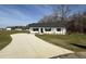 Charming single-story home with a white exterior, black shutters, and a long concrete driveway at 107 Faucette Dr, Selma, NC 27576