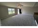 Bright living room featuring plush carpeting, a ceiling fan, and a large window at 107 Faucette Dr, Selma, NC 27576