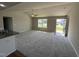 Bright living room featuring plush carpeting, a ceiling fan, and a large window at 107 Faucette Dr, Selma, NC 27576
