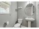 Powder room with pedestal sink, toilet, and window at 111 Daneborg Rd, Durham, NC 27703