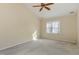 Well-lit bedroom with a ceiling fan and large window providing natural light for a cozy atmosphere at 11820 Fairlie Pl, Raleigh, NC 27613