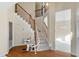 Open foyer featuring hardwood floors, staircase with wooden railing, and a chairlift at 11820 Fairlie Pl, Raleigh, NC 27613