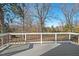 Spacious back deck with a railing, overlooking a serene wooded yard with mature trees at 1204 Donphil Rd, Durham, NC 27712