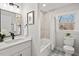 Bathroom features tub-shower combo, modern vanity, black fixtures, and bright natural light from window at 1204 Donphil Rd, Durham, NC 27712