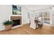 Elegant dining area with a brick fireplace, hardwood floors, and a sliding door to a deck at 1204 Donphil Rd, Durham, NC 27712