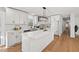 Bright modern kitchen with white cabinets, quartz countertops, and stainless appliances; seamlessly flows into other rooms at 1204 Donphil Rd, Durham, NC 27712