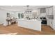 Modern kitchen with white cabinets, stainless steel appliances, large island, and hardwood floors throughout at 1204 Donphil Rd, Durham, NC 27712