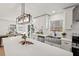 Bright kitchen featuring white cabinets, a stainless steel farmhouse sink, quartz countertops, and access to a deck at 1204 Donphil Rd, Durham, NC 27712