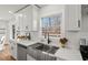 Close up of kitchen sink with white quartz countertop, stainless steel dish rack and subway tile backsplash at 1204 Donphil Rd, Durham, NC 27712