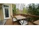 Wooden deck with a dining set and a treed backdrop and access to the house at 1226 Woodland Church Rd, Wake Forest, NC 27587