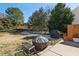 Wide backyard view with a fire pit and outdoor grill. Some snow is present at the edge of the yard at 12566 Honeychurch St, Raleigh, NC 27614