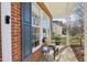 Charming front porch with brick accents and cozy chair and table setting at 12566 Honeychurch St, Raleigh, NC 27614