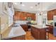 Well-lit kitchen featuring wood cabinets, granite countertops, stainless steel appliances, and a center island at 12566 Honeychurch St, Raleigh, NC 27614