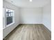 Bright bedroom with wood-look floors, a large window overlooking the neighborhood, and neutral walls at 1336 Weavers Trace Dr, Zebulon, NC 27597