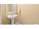 Half bathroom features a pedestal sink, modern faucet, and a decorative framed mirror at 1420 Springshire Ct, Raleigh, NC 27610