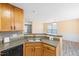 Well-lit kitchen sink with wood cabinets and an adjacent dining area at 1420 Springshire Ct, Raleigh, NC 27610