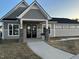 Charming building with a stone pillar entryway, black doors, and neutral siding at 145 Plantation Dr, Youngsville, NC 27596