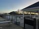 Community pool area enclosed by a black fence, with picnic tables, chairs, and sunset views at 145 Plantation Dr, Youngsville, NC 27596