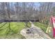 Spacious backyard featuring a brick paver patio with a fire pit and a winding walkway through the grass to the fence at 1600 Patterson Grove Rd, Apex, NC 27502