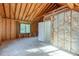Unfinished basement with wood framing, insulation, exposed beams, and a window at 1600 Patterson Grove Rd, Apex, NC 27502