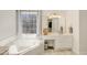 Bright bathroom featuring a corner bathtub with jets, a vanity with a makeup area and a large window at 1600 Patterson Grove Rd, Apex, NC 27502