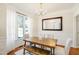 Formal dining room featuring a stylish wood table set, decorative lighting, and large windows at 1600 Patterson Grove Rd, Apex, NC 27502