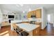 Open kitchen featuring an island, stainless steel appliances, and hardwood flooring at 1600 Patterson Grove Rd, Apex, NC 27502