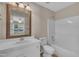 Traditional bathroom with a large framed mirror, white vanity, toilet, and tiled tub-shower at 1614 W Cotton Gin Dr, Clayton, NC 27527