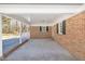 Covered carport of brick home with white pillars and concrete flooring providing ample parking space at 1702 Nc 242 N, Benson, NC 27504