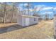 Exterior view of the detached outbuilding with white door, window and siding at 1702 Nc 242 N, Benson, NC 27504