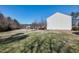 A spacious backyard with a view of the wooded area and the side of the house at 174 St. Andrews Ln, Chapel Hill, NC 27517
