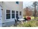 Cozy patio with an outdoor table, four chairs, and a red grill surrounded by landscaping at 174 St. Andrews Ln, Chapel Hill, NC 27517