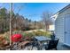 Cozy patio with an outdoor table, four chairs, and a red grill with a backyard view at 174 St. Andrews Ln, Chapel Hill, NC 27517