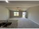 Open-concept living area with neutral walls, carpeted floors, ceiling fan and granite countertops in the kitchen area at 197 Pate Landing Dr, Selma, NC 27576