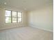 Bright bedroom with large window, neutral paint, and plush carpeting at 205 Big Bradley Dr, Wendell, NC 27591