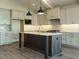 An island kitchen features modern appliances, pendant lighting and white cabinets at 205 Big Bradley Dr, Wendell, NC 27591