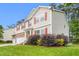 Well-manicured lawn and landscaping compliment the two-story home with red shutters and vinyl siding at 211 Whitney Ln, Durham, NC 27713